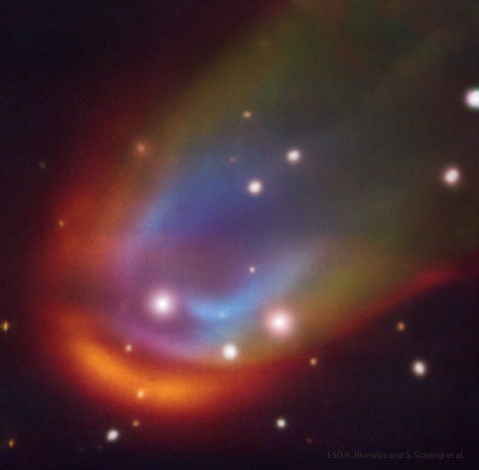 Kolorowy obraz fali uderzeniowej (bow shock) wokół białego karła RXJ0528+2838, uzyskany z instrumentu MUSE na VLT: gwiazdy tła oraz podłużny, barwny obłok biegnący ukośnie przez kadr, z zaznaczeniem położenia białego karła