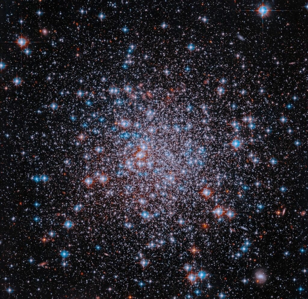 Tysiące białych i niebieskich gwiazd gromady kulistej NGC 6426 na czarnym tle kosmosu.