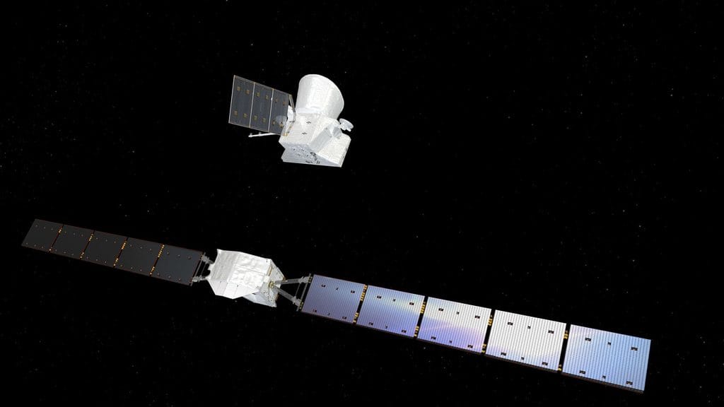 Ilustracja przedstawia sondę BepiColombo w przestrzeni kosmicznej, na tle czarnego nieba usianego drobnymi gwiazdami. Na pierwszym planie, w dolnej części obrazu, znajduje się Mercury Transfer Module z dużym białym korpusem i dwoma długimi, rozłożonymi panelami słonecznymi. Nad nim, w pewnej odległości, widoczny jest oddzielony orbiter naukowy z jasnym korpusem, osłoną oraz jednym prostokątnym panelem słonecznym. Ilustracja pokazuje moment po odłączeniu modułu transferowego od pozostałej części sondy podczas rozpoczynania fazy przybycia do Merkurego.
