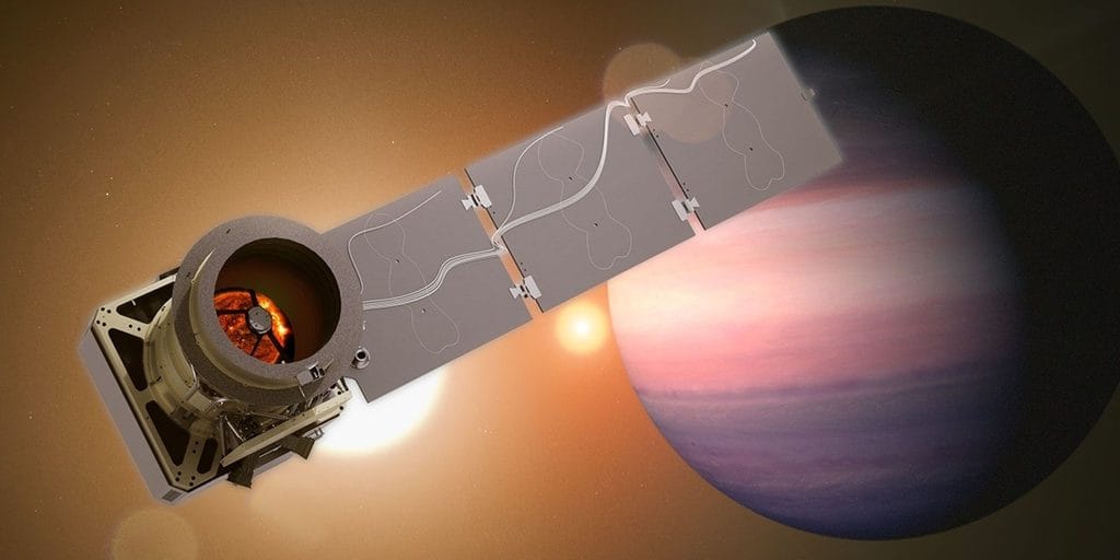 Na ilustracji widać artystyczną wizualizację satelity Pandora obserwującego egzoplanetę. Na lewym brzegu obrazu znajduje się jasnobeżowy, cylindryczny teleskop z okrągłym otworem skierowanym w stronę prawej krawędzi; wewnątrz tubusu widać pomarańczowo‑czerwony, rozżarzony dysk przypominający fotografię gwiazdy lub Słońca. Od teleskopu w prawo ciągnie się długa, wąska konstrukcja z kilku prostokątnych paneli – to rozłożone, szare skrzydło satelity, na którym widoczne są delikatne, jasne linie w kształcie wijących się ścieżek. Po prawej stronie większość kadru zajmuje duża, kulista planeta w pastelowych barwach: jej atmosfera ma szerokie poziome pasy w kolorach różu, jasnej czerwieni, fioletu i błękitu; dolna część planety jest ciemniejsza, jakby pogrążona w cieniu. Tło całej sceny jest ciepłe, brązowo‑złote, z rozmytymi, jasnymi plamami światła sugerującymi inne gwiazdy, dzięki czemu całość wygląda jak ujęcie małego satelity, który z bliska przygląda się odległemu, gazowemu olbrzymowi w obcym układzie planetarnym.